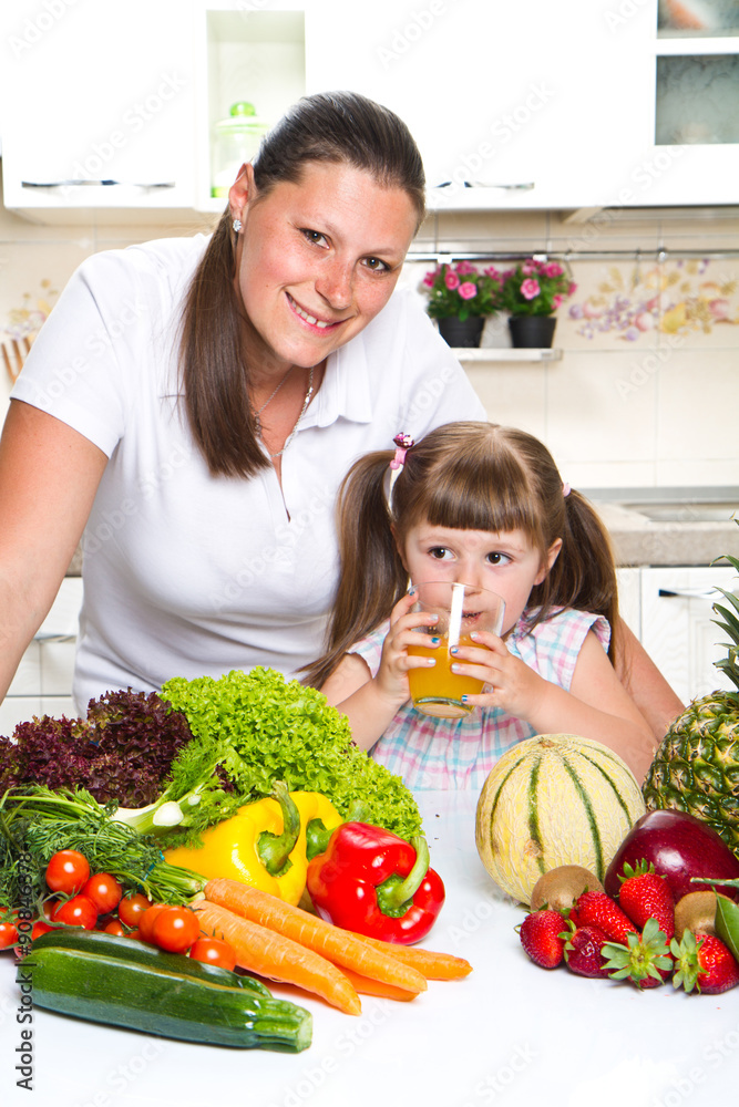 Beautiful young woman gives to the little girl orange juice  in