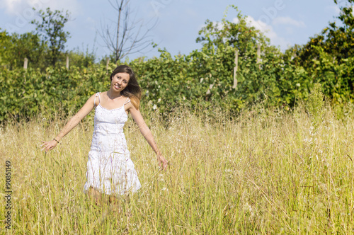 Young woman in the field wearing white dress