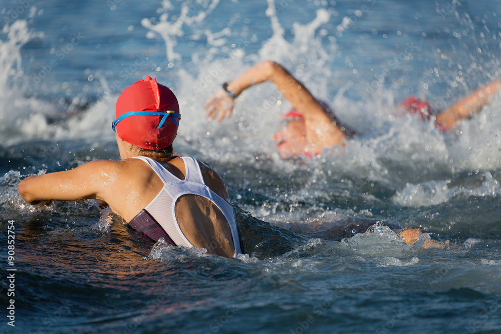 Group people in wetsuit swimming at triathlon