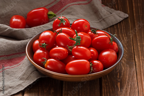 Tomatoes / Fresh red cherry tomatoes in ceramic bowl on rustic wooden table