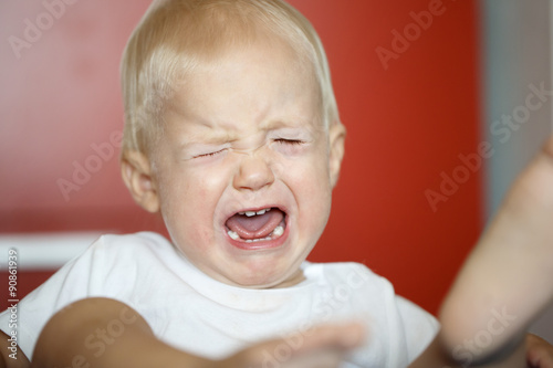 Small, crying and raging toddler having a temper tantrum