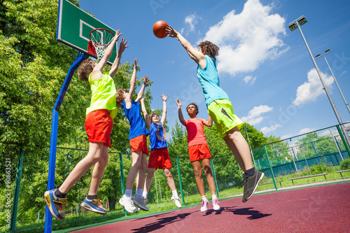 Children jump for ball during basketball game © Sergey Novikov