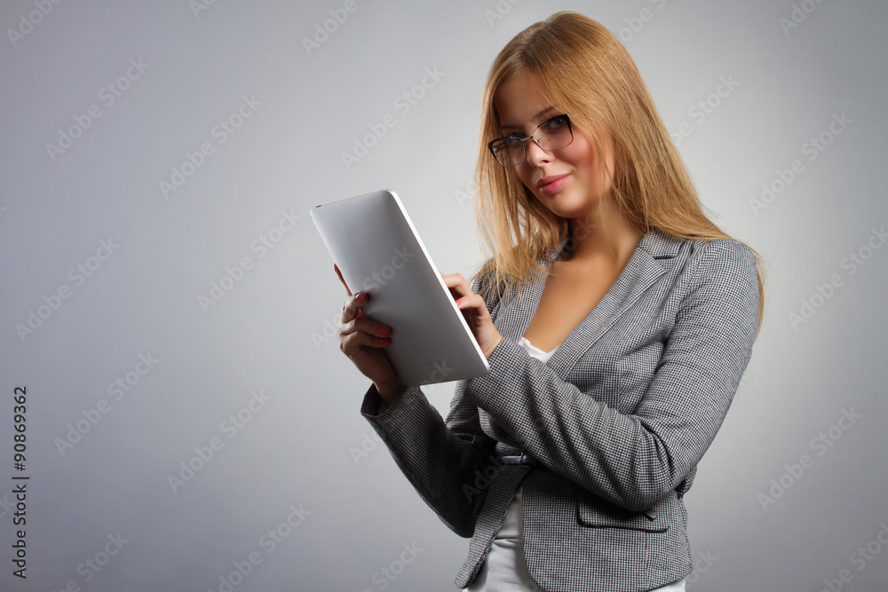 Young woman in glasses with tablet computer PC on grey Young woman in glasses with tablet computer PC on grey
