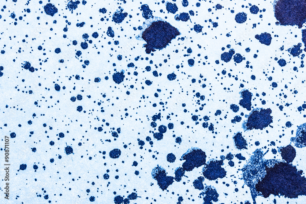 Black ink stains on blue paper.