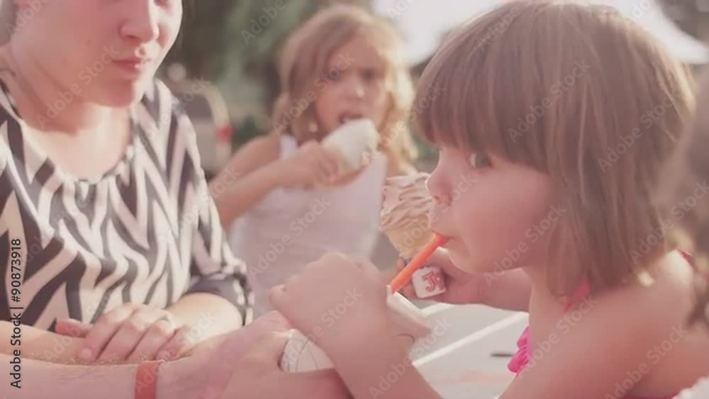 A father shares his drink with his daughter at a picnic table
A father shares his drink with his daughter at a picnic table