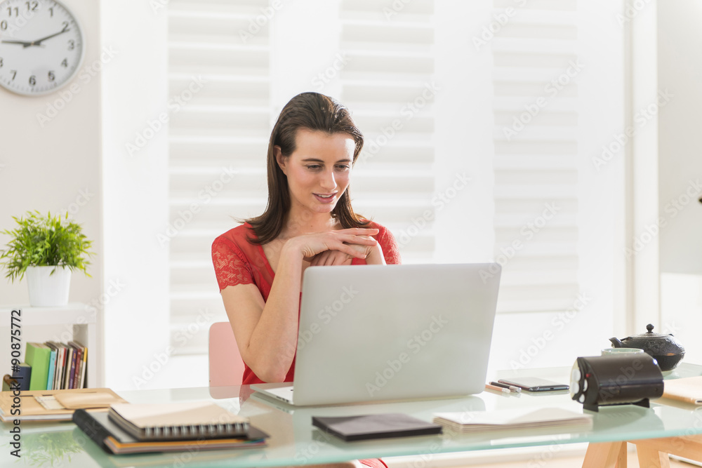 At office, modern businesswoman examining a project on a laptop At office, modern businesswoman examining a project on a laptop