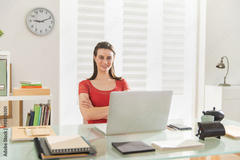 Looking at camera a modern businesswoman works on a laptop Looking at camera a modern businesswoman works on a laptop