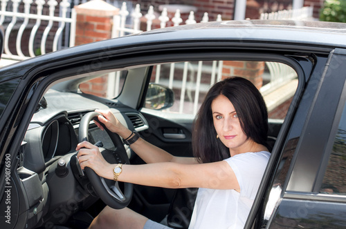 Woman in her late 30s to early 40s in a car happy to have passed the driver’s license test