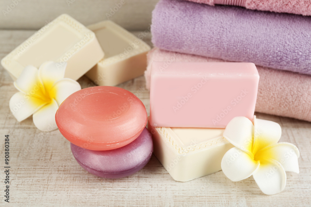 Bars of natural soap and colorful towels on light background Bars of natural soap and colorful towels on light background