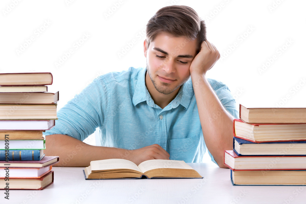 Young man reading book at table on white background Young man reading book at table on white background