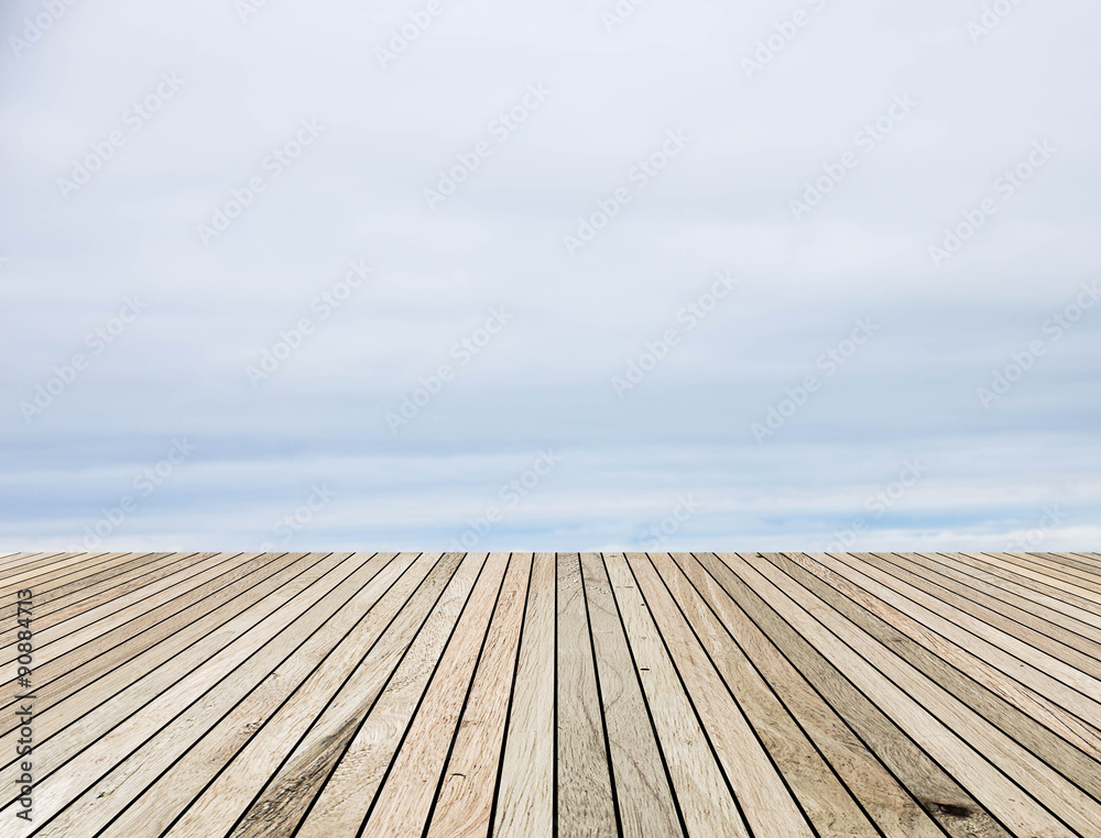 Wood plank over blurred clouds sky background