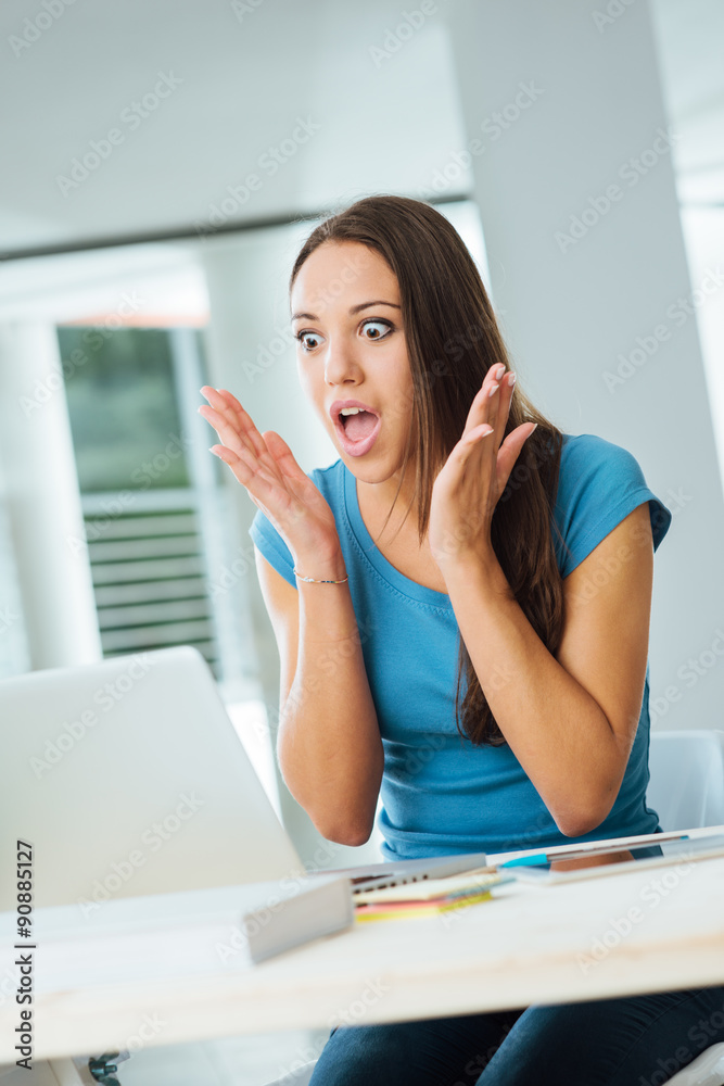 Shocked young woman using a laptop Shocked young woman using a laptop