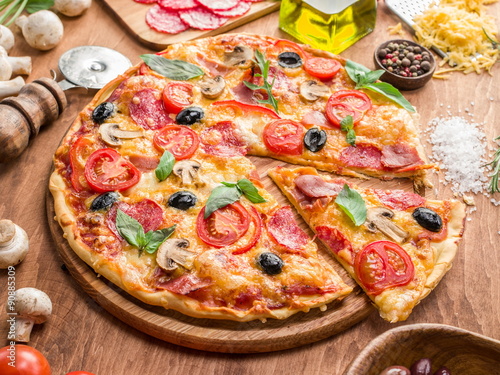 Pizza with mushrooms, salami and tomatoes.