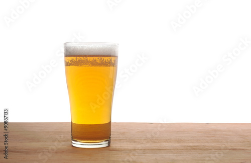 Glass of beer on wooden bar isolated