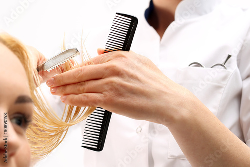 obcinanie włosów.Fryzjer strzyże kobietę nożem chińskim w salonie fryzjerskim
