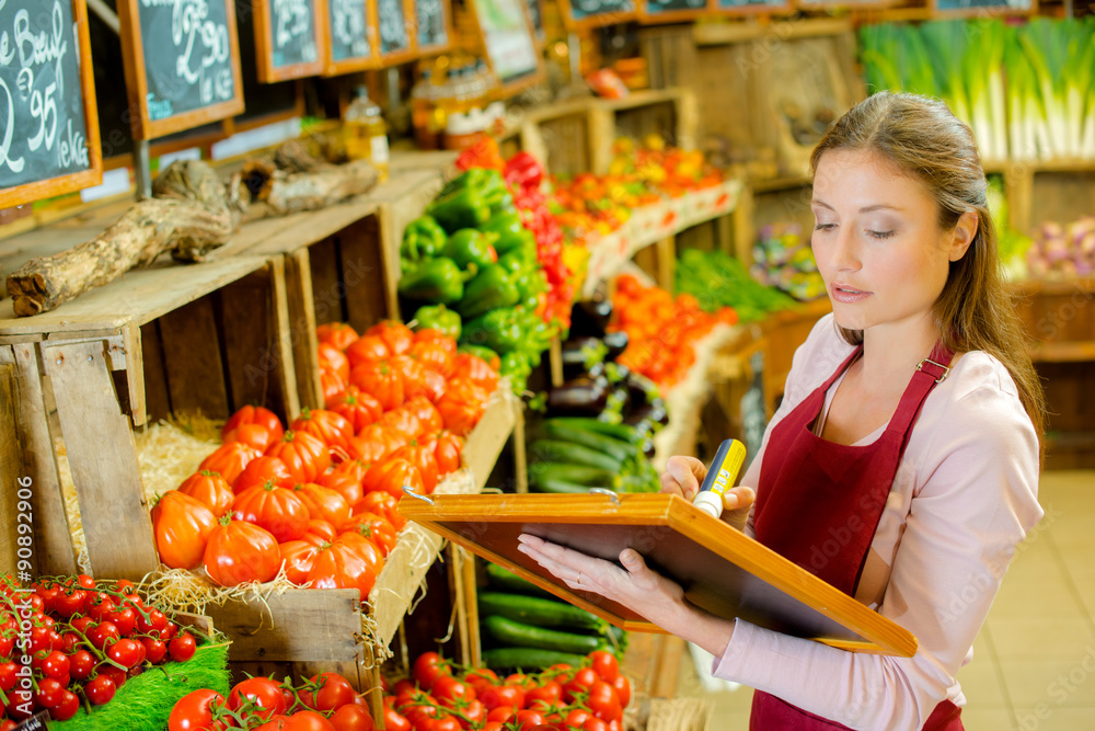 Obraz premium Worker writing prices onto board