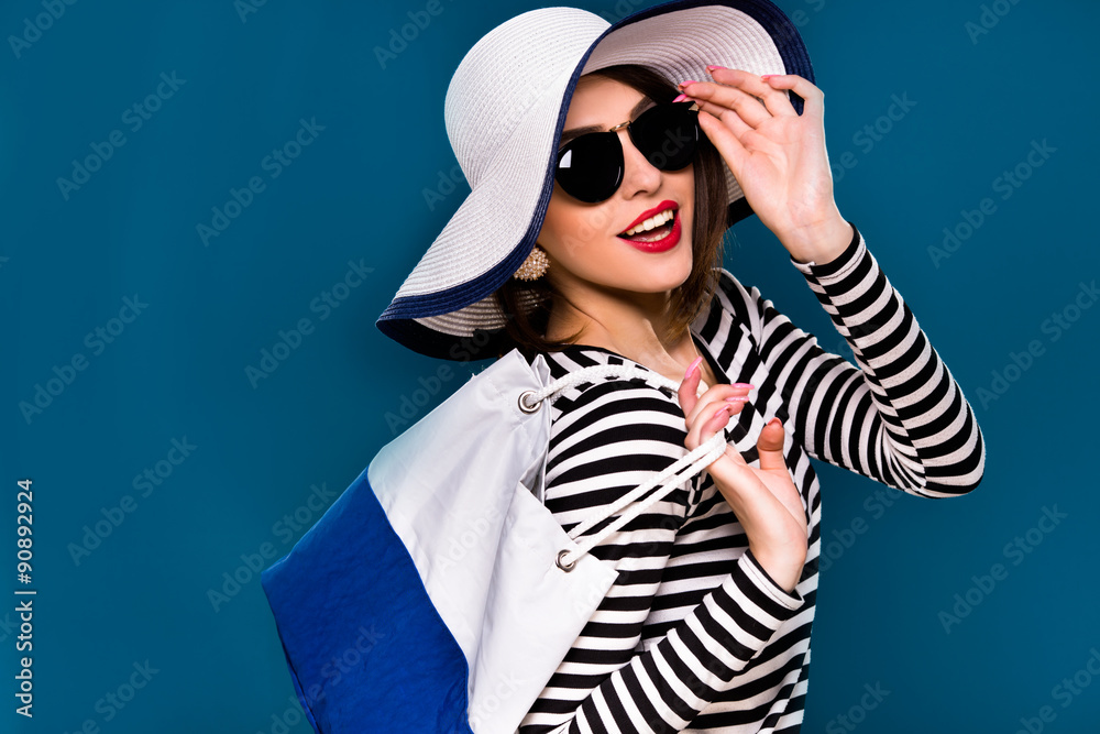 Cute smiling woman is posing with white and blue bag Cute smiling woman is posing with white and blue bag