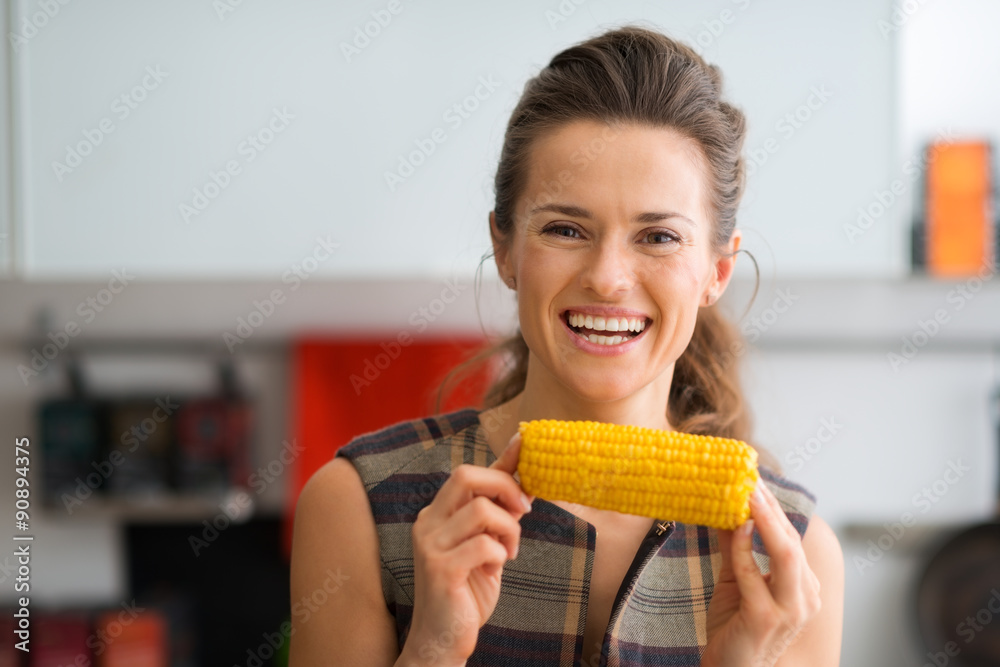 Smiling woman holding corn cob