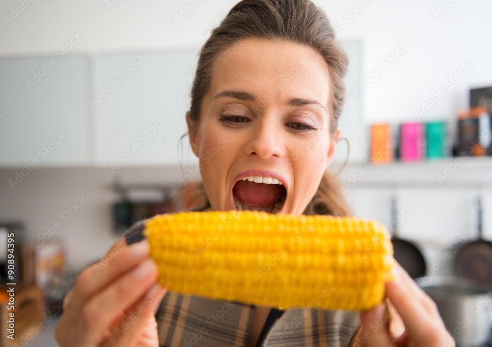 Closeup of woman opening mouth wide to take bite of corncob Closeup of woman opening mouth wide to take bite of corncob