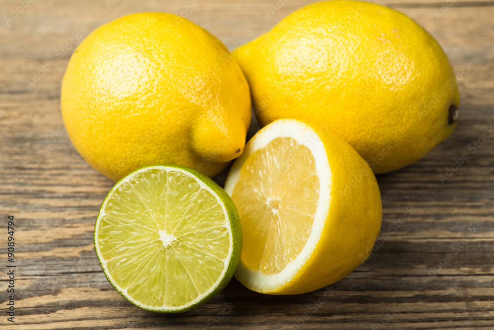 Fresh and juicy lemons and lime on a wooden surface Fresh and juicy lemons and lime on a wooden surface