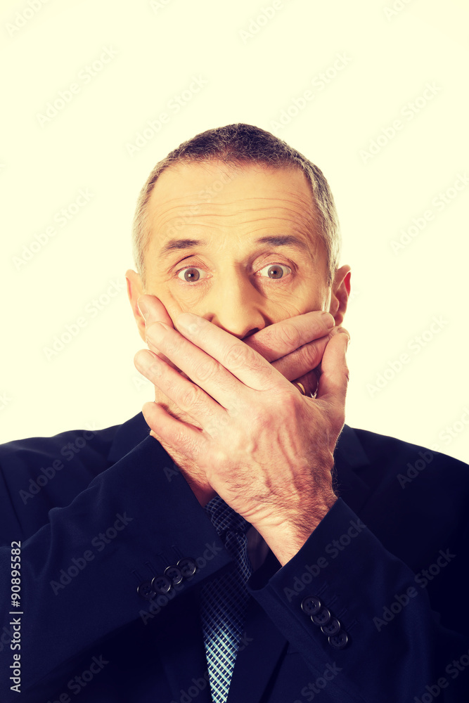 Portrait of businessman covering mouth Portrait of businessman covering mouth
