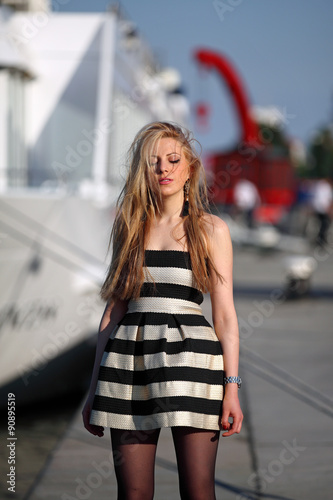 Young girl dreaming in front of a ship at a river