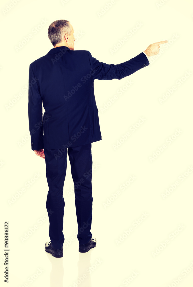 Full length back view businessman pointing right Full length back view businessman pointing right