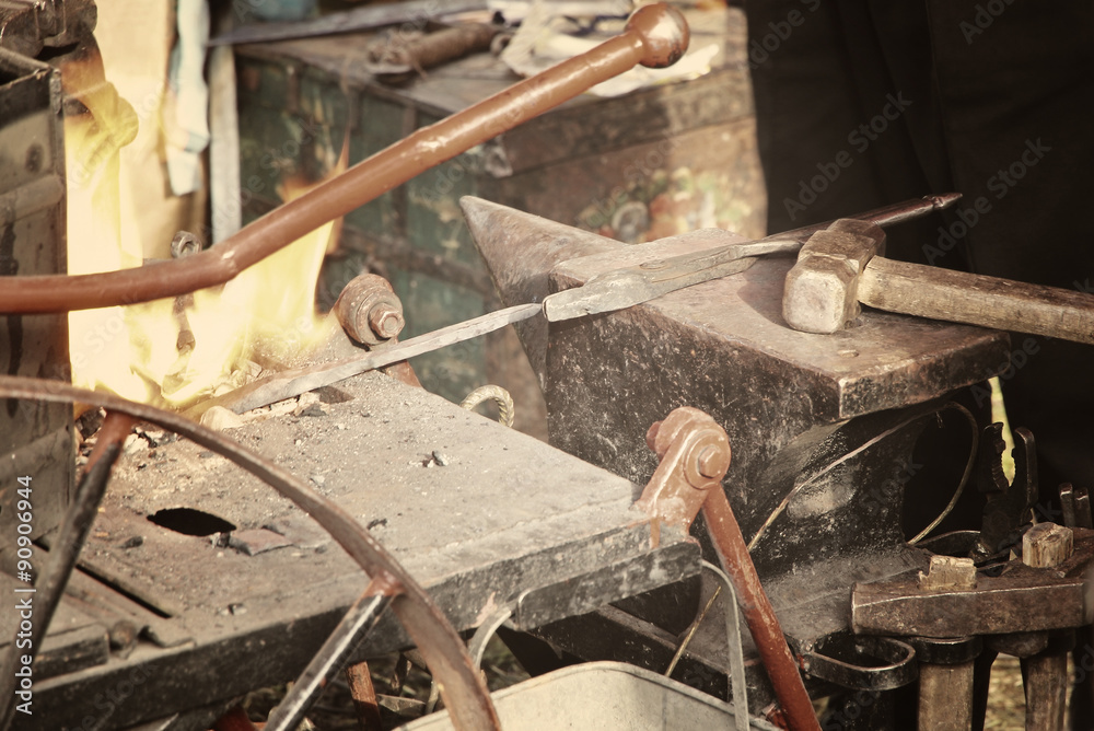 Blacksmith workshop with anvil and fire.Toned image. Blacksmith workshop with anvil and fire.Toned image.