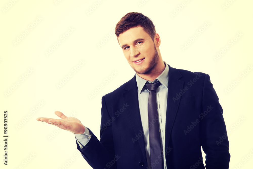 Handsome businessman holding copyspace on palm. Handsome businessman holding copyspace on palm.