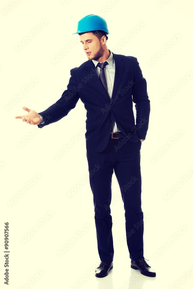 Businessman with hard hat holding copy space.