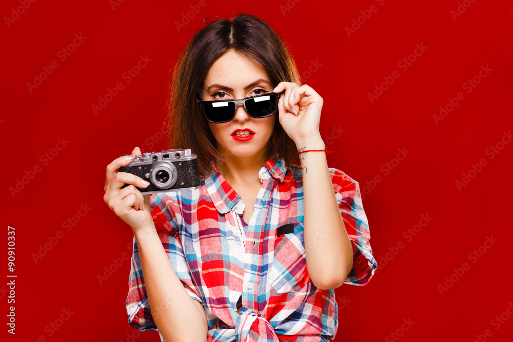 Pretty girl posing with retro camera on red background Pretty girl posing with retro camera on red background