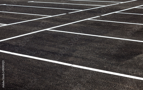 White traffic markings on a gray asphalt parking lot