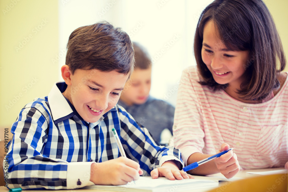 group of school kids writing test in classroom group of school kids writing test in classroom