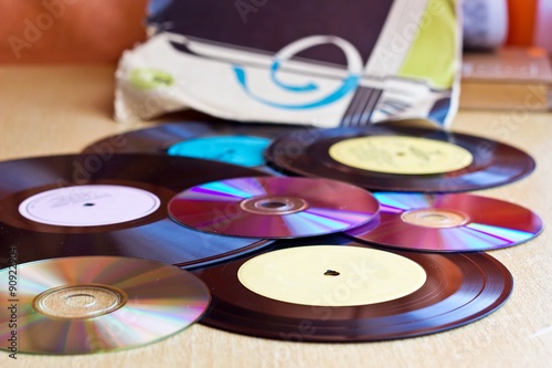 Background with Vinyl record discs ans CD. Focus on foreground. Image with blurred background