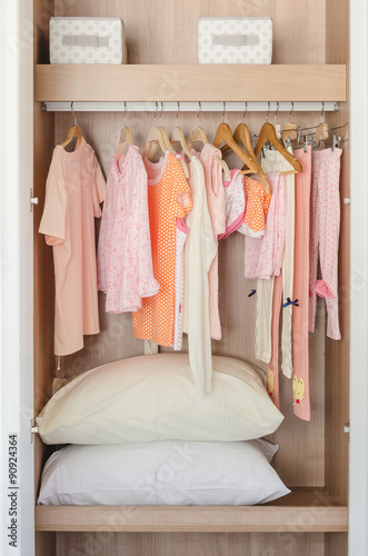 kid's wooden wardrobe with clothes hanging © 290712