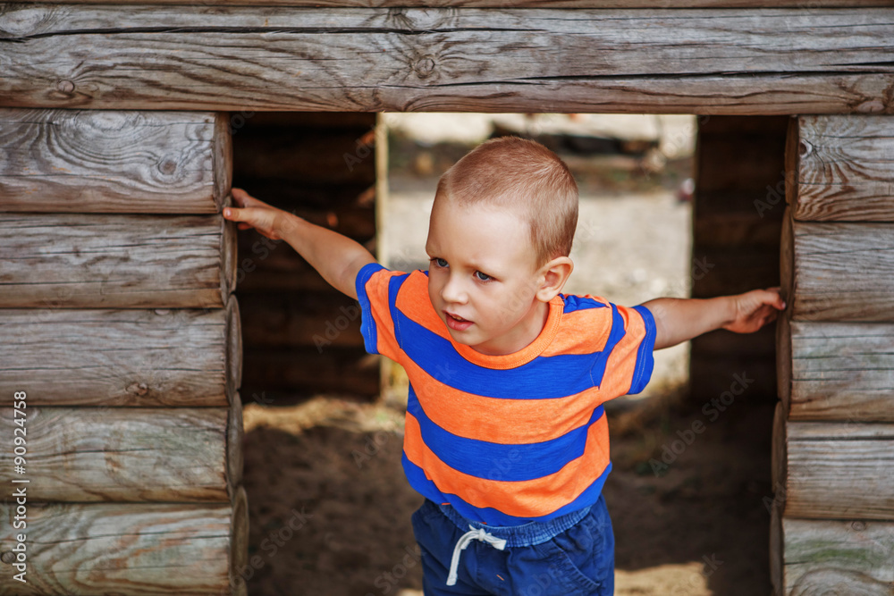 Cute little boy playing on the playground in the summer