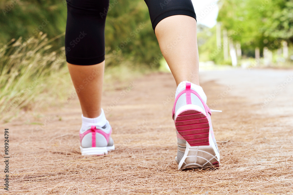 Runner feet running on road closeup on shoe Runner feet running on road closeup on shoe