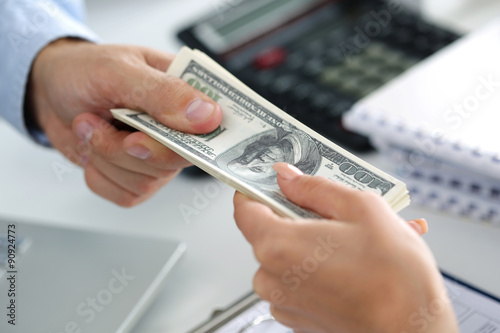 Man taking batch of hundred dollar bills