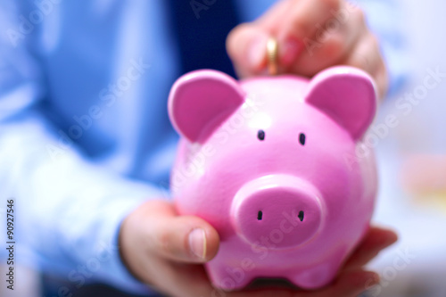 Businessman holding piggy box ,standing in office