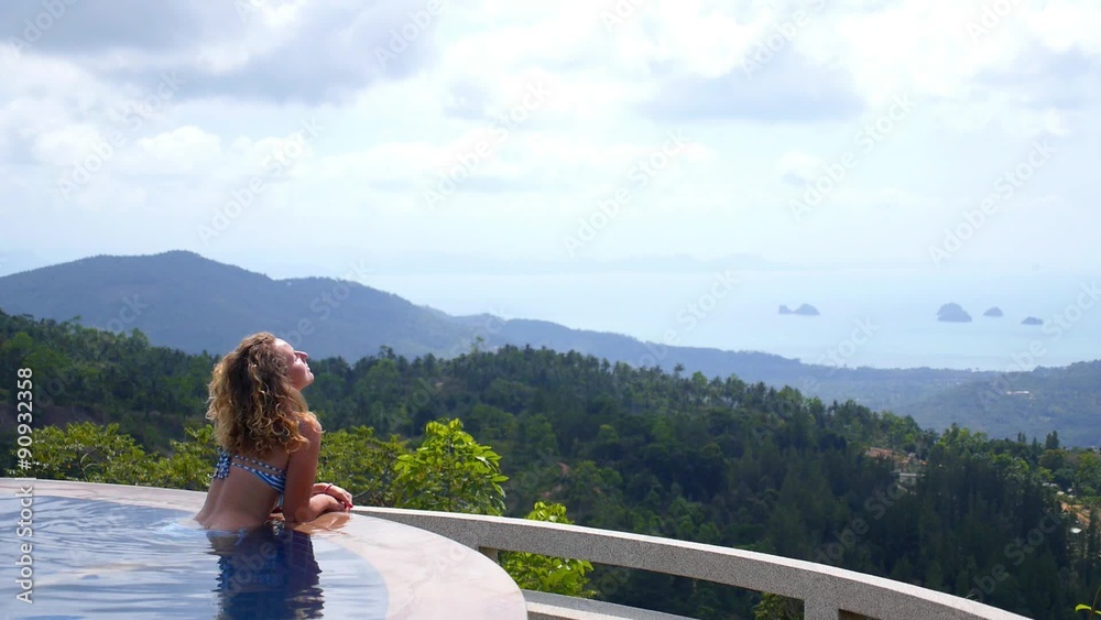 Woman Relaxing in Swimming Pool Enjoying Sea View Woman Relaxing in Swimming Pool Enjoying Sea View