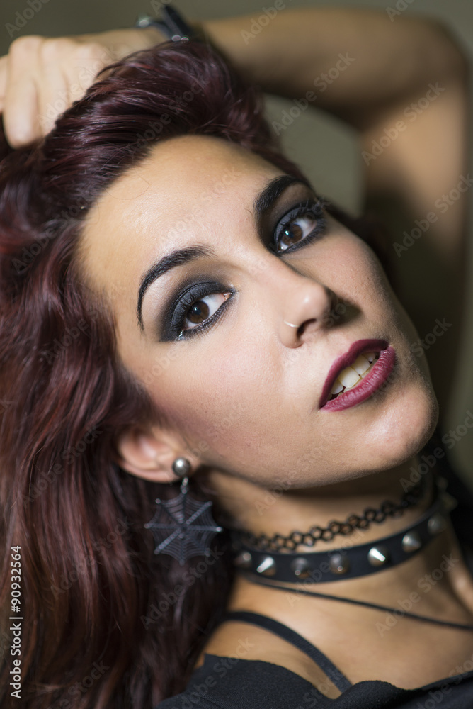 Young woman with gothic and heavy metal style posing on dirty wa Young woman with gothic and heavy metal style posing on dirty wa
