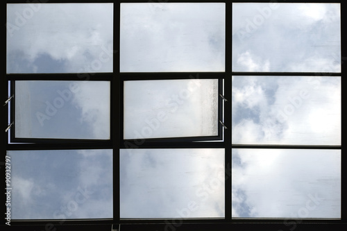 Dachfenster / Durch ein Glasdach scheint der blaue Wolkenhimmel