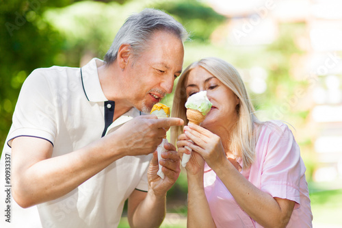  Happy couple eating an ice cream in a park