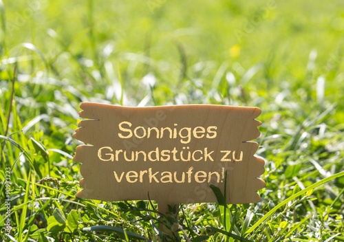 Sonniges Grundstück zu verkaufen - Tafel in grüner Wiese © stockpics