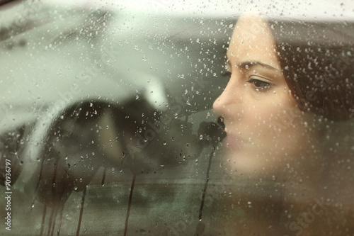 Obraz na plátně Smutná žena dívá skrz okno auta