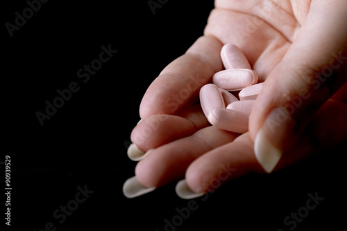 Картината върху платно pink pills under female hand female viagra