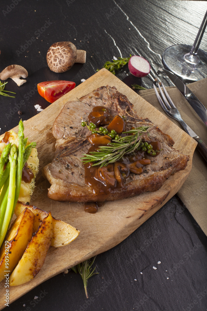 T-bone steak, a prepared piece of grilled T-bone steak brown sauce with mashed potato and vegetable on dining table decorated T-bone steak, a prepared piece of grilled T-bone steak brown sauce with mashed potato and vegetable on dining table decorated