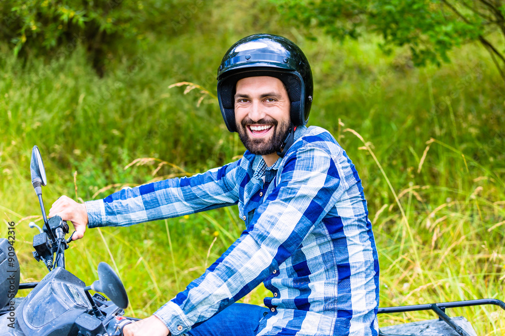 Man driving off-road with quad bike or ATV Man driving off-road with quad bike or ATV