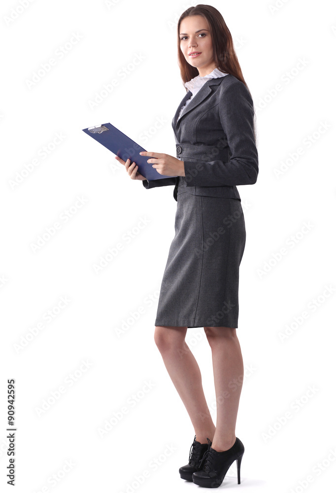 Attractive young businesswoman standing near desk with folder in Attractive young businesswoman standing near desk with folder in