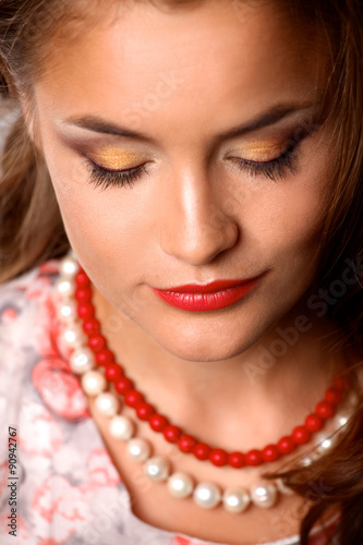 Portrait of young beautiful brunette woman in beads 